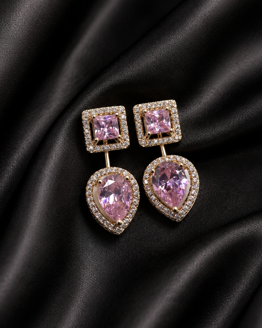 Pair of pink gemstone earrings on black satin fabric