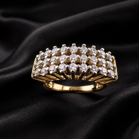 A gold ring with three rows of clear round-cut gemstones, displayed on a draped black satin fabric background.