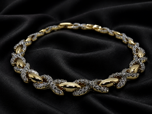 Gold necklace with diamond accents on a black fabric background
