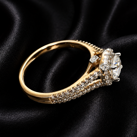 A yellow gold ring with a large oval-cut clear center stone and smaller pavé-set stones along the band, displayed on a draped black satin fabric background.