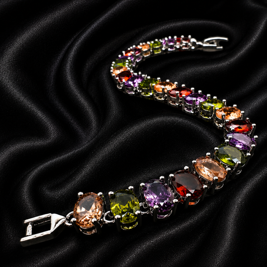 A silver-tone bracelet with multiple colorful gemstones in a curved arrangement, displayed on a draped black satin fabric background.