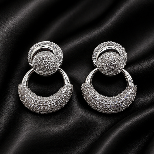 Pair of silver hoop earrings on black satin fabric