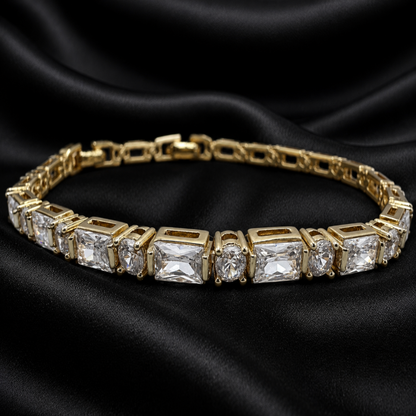 Gold bracelet with clear gemstones on a black satin background
