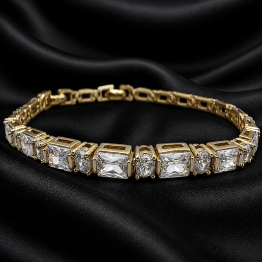 Gold bracelet with clear gemstones on a black satin background