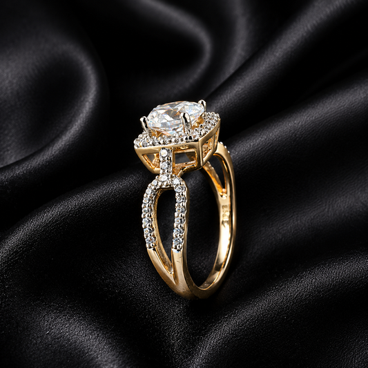 A gold ring with a large clear round-cut center stone and small clear stones along the band, displayed on a black satin fabric background.