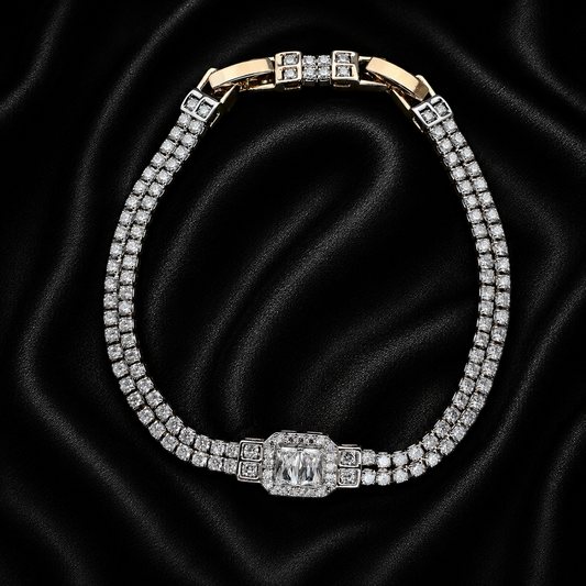 A double-row diamond tennis bracelet with a gold-plated clasp and a central rectangular diamond, displayed on a black satin fabric background.