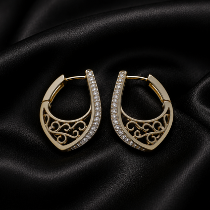 Gold hoop earrings with intricate designs on a black satin background