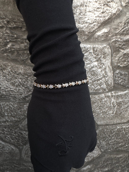 Bracelet on a gloved hand against a stone wall background
