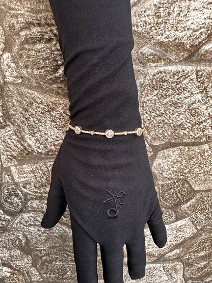 Black glove with a gold bracelet on a textured stone background
