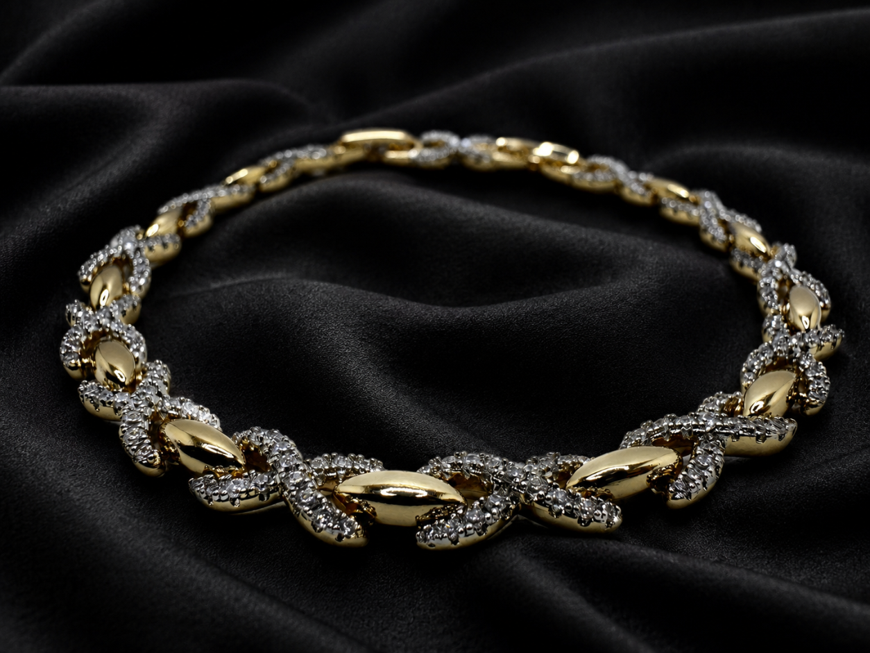 Gold necklace with diamond accents on a black fabric background