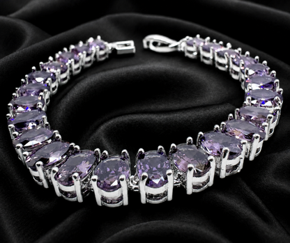 Silver bracelet with purple gemstones on a black satin background