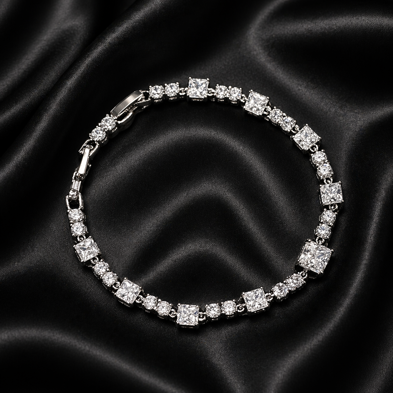 Silver bracelet with clear stones on a black satin background