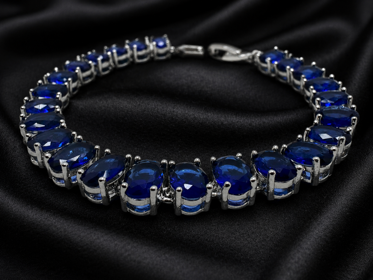 Silver bracelet with blue gemstones on a black satin background