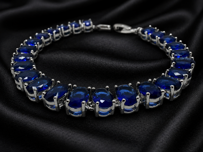 Silver bracelet with blue gemstones on a black satin background
