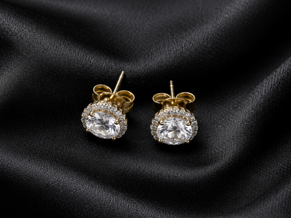 Gold and diamond earrings on black satin fabric