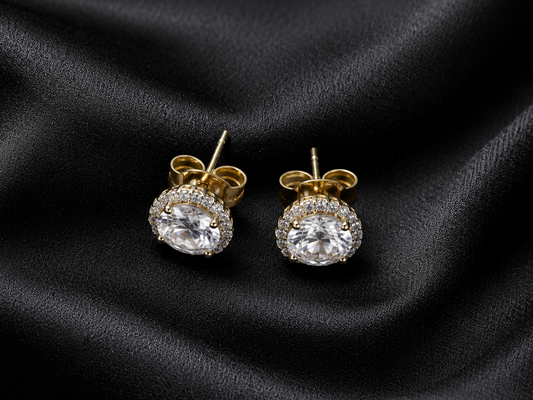 Gold and diamond earrings on black satin fabric